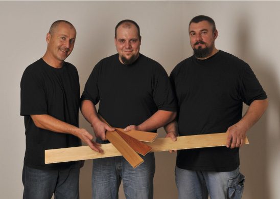 Die drei Gründer von KAGOMA, Karl-Heinz Hofmann, Goran Pjevalo und Mathias Rühle, mit einer Parkettdiele